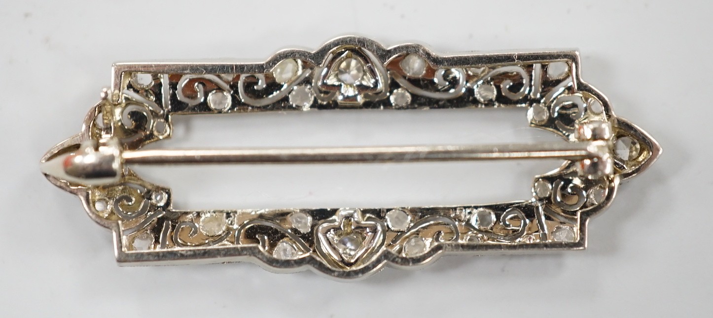 A 1940's/1950's pierced yellow metal and millegrain set round and rose cut diamond open work brooch, 33mm, gross weight 2.7 grams.